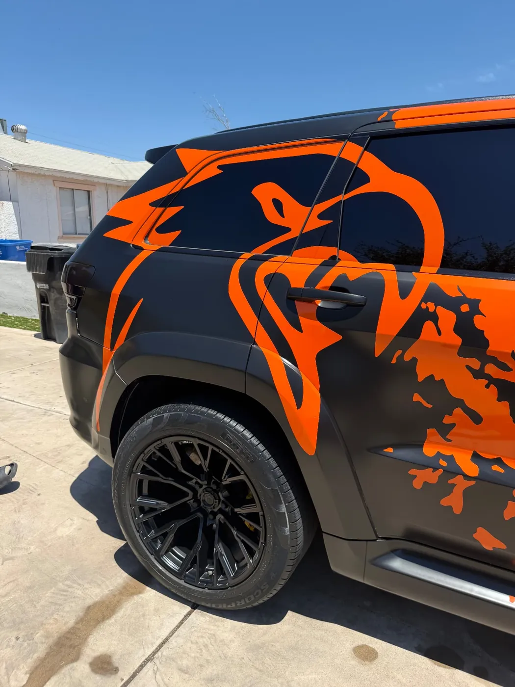 Satin black and orange custom vinyl wrap on a Jeep Trackhawk cleaned with wrap-safe products in Arizona