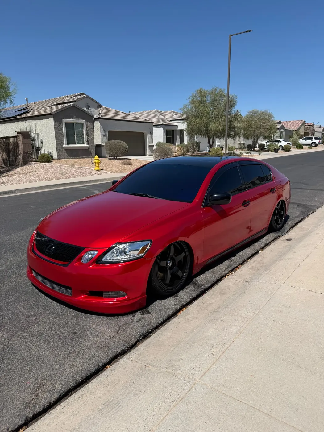 Red Lexus GS with candy-red paint detailed curbside in a Surprise, Arizona neighborhood