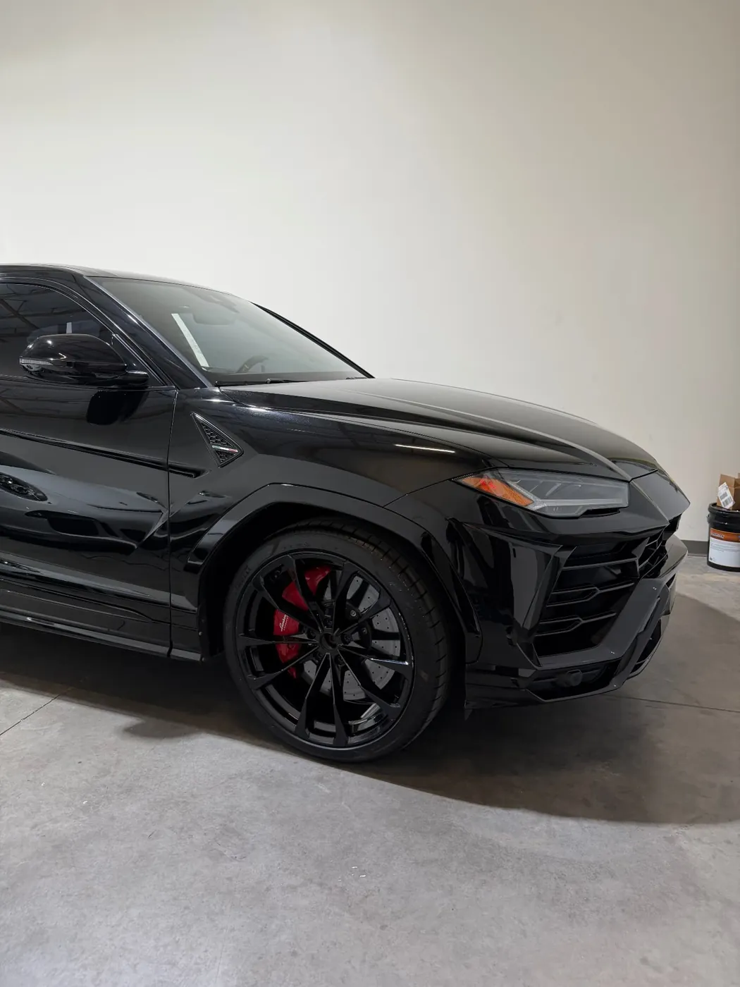 Side profile of a black Lamborghini Urus with deep reflective paint after a ceramic-prep detail