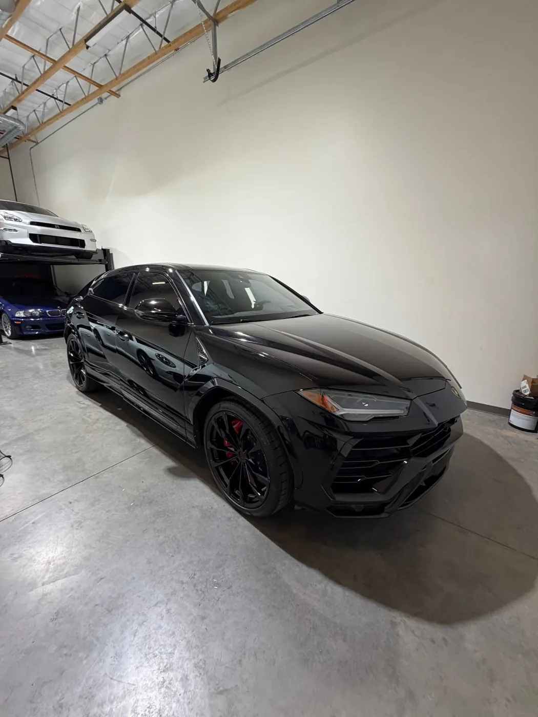 Black Lamborghini Urus detailed to a wet-look shine inside a Phoenix Metro garage