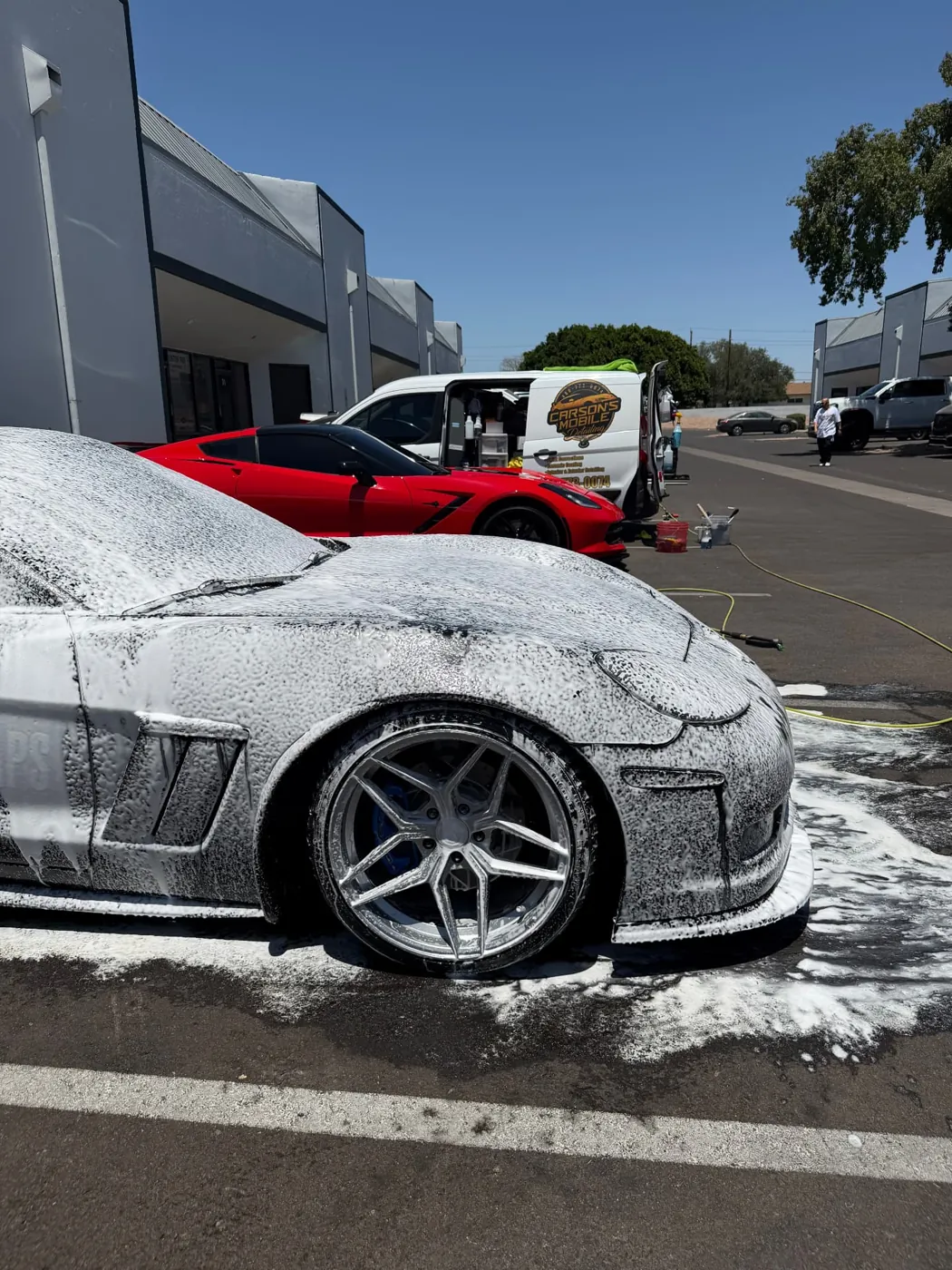 Chevrolet Corvette covered in thick snow foam during a safe two-bucket mobile hand wash in Phoenix