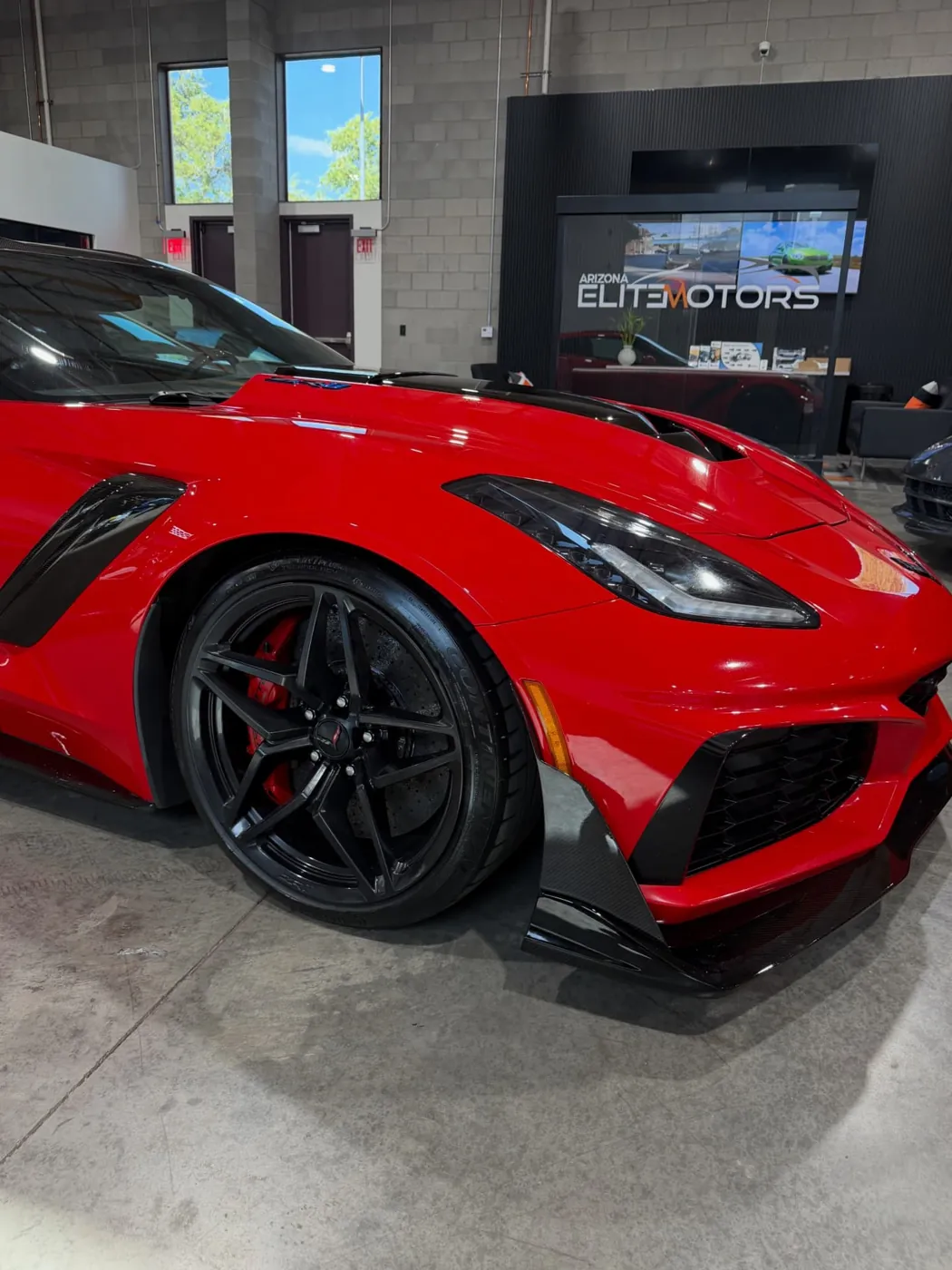 Close-up of a red Corvette ZR1 front fender and gloss black wheel after paint correction in Arizona
